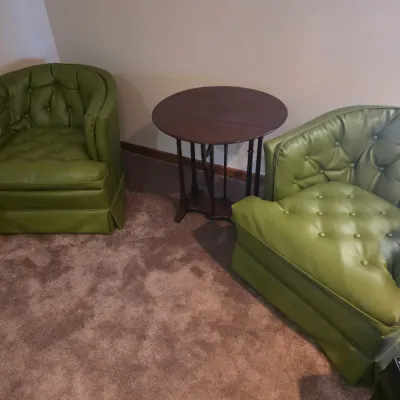 Sale Photo Thumbnail #116: Pair of mid-century modern tufted barrel chairs in avocado green vinyl upholstery, flanking a dark wood drop-leaf gateleg side table.