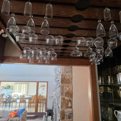 Sale Photo Thumbnail #22: Assorted glassware hanging from an overhead wooden rack in a home bar area.