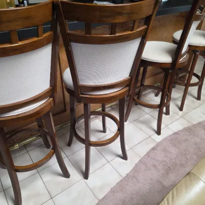 Sale Photo Thumbnail #16: Set of four contemporary swivel bar stools with dark wood frames, upholstered seats, and curved backs.