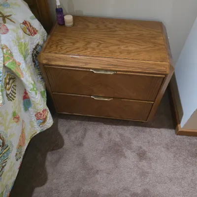 Sale Photo Thumbnail #14: Vintage oak nightstand featuring two drawers with chevron-patterned wood grain and brass-toned pulls, circa 1980s.