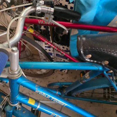 Sale Photo Thumbnail #95: Vintage Schwinn World Tourist bicycle in blue, shown alongside a red Schwinn Varsity bicycle.