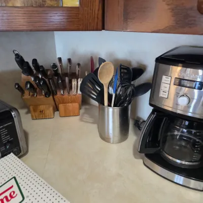 Sale Photo Thumbnail #58: Cuisinart 14-cup programmable coffeemaker alongside kitchen utensils in a stainless steel crock and two wooden knife blocks with assorted knives.