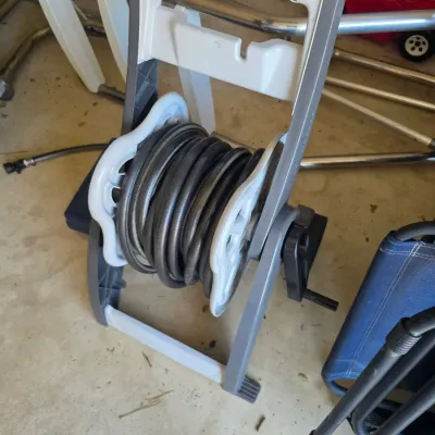 Sale Photo Thumbnail #107: Suncast plastic garden hose reel cart with a black hose, showing light wear from outdoor use.
