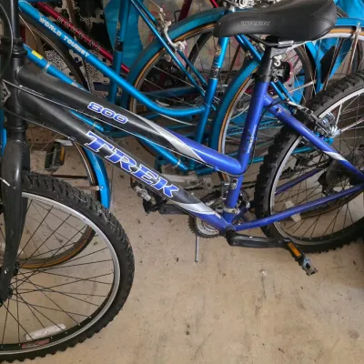 Sale Photo Thumbnail #92: Trek 800 Sport mountain bike in blue and black, shown alongside other vintage bicycles including a blue Schwinn World Tourist.
