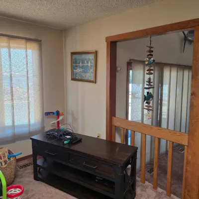 Sale Photo Thumbnail #18: Dark wood and metal media console table with drawers and open shelving, shown alongside a framed nautical painting and a hanging fish mobile.