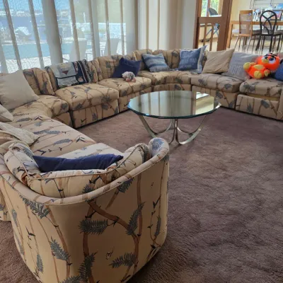 Sale Photo Thumbnail #2: Large vintage modular sectional sofa with tropical bamboo-patterned upholstery, accompanied by a matching armchair and a circular glass-top coffee table with a chrome base.