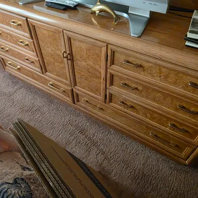 Sale Photo Thumbnail #74: Vintage oak triple dresser featuring burl wood veneer drawer fronts, brass hardware, and a central cabinet compartment.
