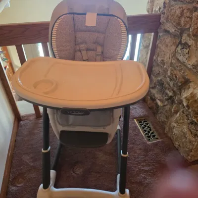 Sale Photo Thumbnail #127: Graco high chair featuring a removable tray, adjustable height, and a padded fabric seat insert in a neutral gray pattern.
