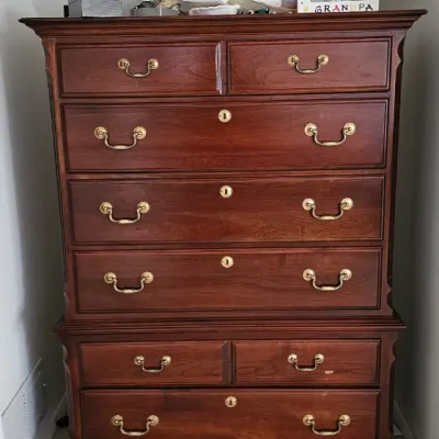 Sale Photo Thumbnail #15: Traditional cherry wood chest-on-chest dresser featuring brass batwing drawer pulls, bracket feet, and a total of eight drawers.