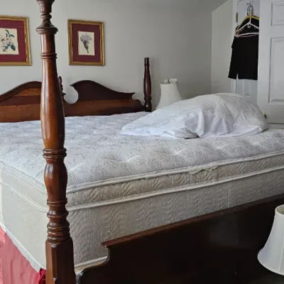 Sale Photo Thumbnail #16: Traditional four-poster wooden bed frame with a mattress and box spring, featuring turned posts and a shaped headboard.