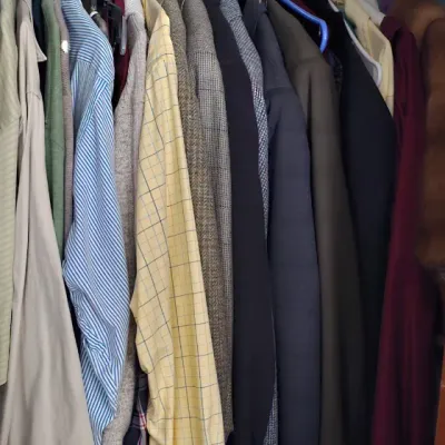 Sale Photo Thumbnail #19: Assorted men's clothing hanging in a closet, including button-down shirts, blazers, and jackets in various colors and patterns.