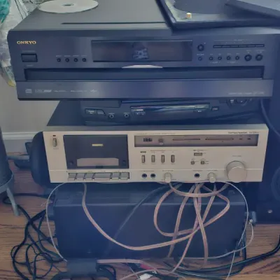 Sale Photo Thumbnail #4: Stack of vintage audio equipment including an Onkyo DX-C390 6-disc CD changer and a Harman Kardon HK385i stereo receiver, shown with associated wiring.