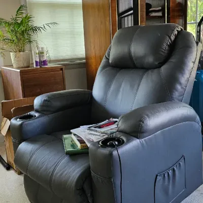 Sale Photo Thumbnail #13: Modern black faux-leather power recliner featuring built-in cup holders and side storage pockets.