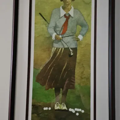 Sale Photo Thumbnail #14: Framed vintage-style art print depicting a female golfer in 1920s attire, presented in a dark wood frame with double matting.