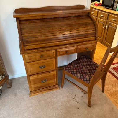 Sale Photo Thumbnail #2: Vintage oak roll-top desk with matching wooden chair featuring a patterned fabric seat cushion.