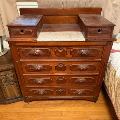 Sale Photo Thumbnail #29: Antique Eastlake-style walnut dresser featuring carved drawer pulls, a small marble-top insert, and two elevated glove drawers, 