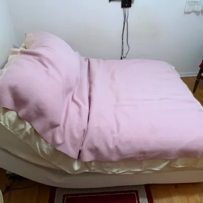 Sale Photo Thumbnail #55: Adjustable electric bed with a white base, shown elevated at the head, 