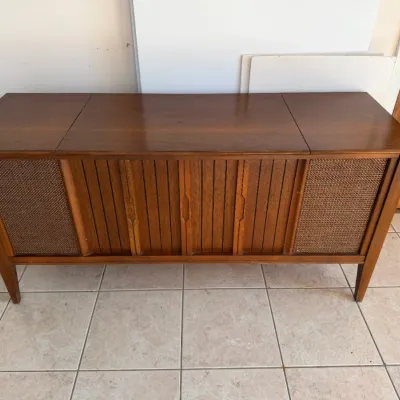 Sale Photo Thumbnail #30: Mid-century modern stereo console cabinet in a warm wood finish, featuring slatted front doors and woven speaker grilles.