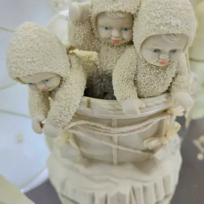 Sale Photo Thumbnail #77: Department 56 Snowbabies porcelain figurine featuring three snowbabies in a basket, showing minor wear.