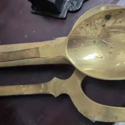 Sale Photo Thumbnail #95: Vintage brass serving spoon and fork set with a worn, tarnished patina.