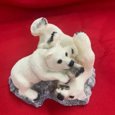 Sale Photo Thumbnail #59: Small resin figurine depicting two playful polar bear cubs on a textured grey base, set against a red background.