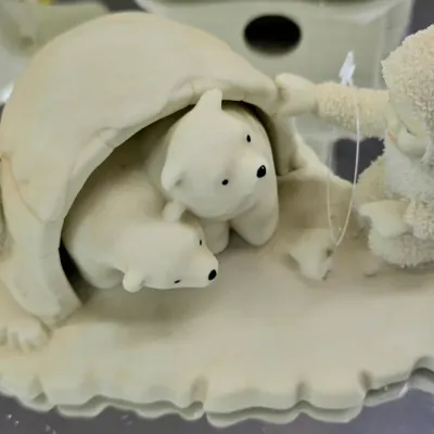 Sale Photo Thumbnail #80: Department 56 Snowbabies bisque porcelain figurine featuring a child fishing next to an igloo with two polar bears inside.