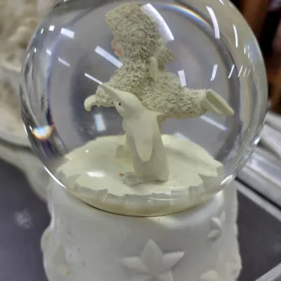 Sale Photo Thumbnail #85: Department 56 Snowbabies snow globe featuring a snowbaby figure with a penguin on a star-embossed base.