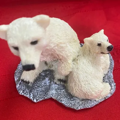 Sale Photo Thumbnail #61: Small resin figurine depicting a polar bear mother and cub on a textured gray base, shown against a red background.