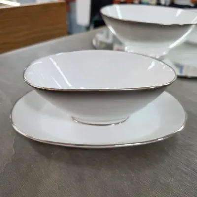 Sale Photo Thumbnail #33: Noritake white porcelain gravy boat with attached underplate, featuring a simple silver rim design.
