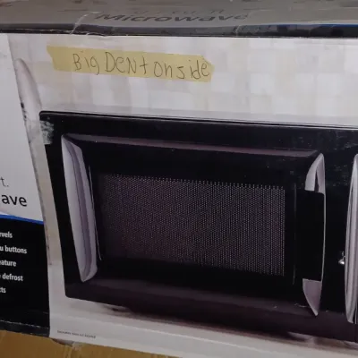 Sale Photo Thumbnail #32: Mainstays 0.7 cubic foot 700-watt microwave in its original box, noted with a handwritten label indicating a dent on the side.