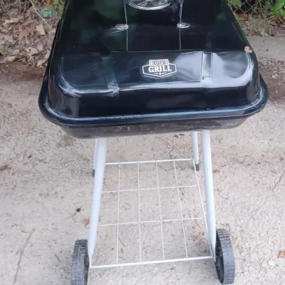Sale Photo Thumbnail #40: Expert Grill black portable charcoal grill with a wheeled stand, showing light wear from outdoor use.