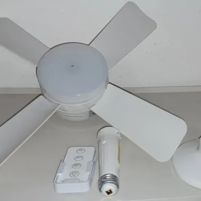 Sale Photo Thumbnail #26: Modern white socket fan light with four blades, remote control, and mounting accessories.