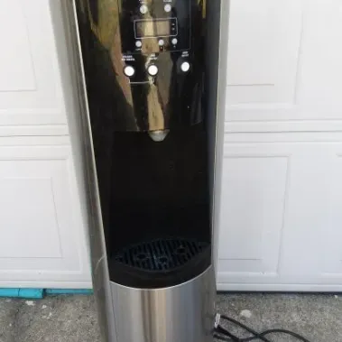 Sale Photo Thumbnail #2: Modern freestanding water dispenser with a stainless steel and black finish, featuring a digital control panel and three dispensing buttons.