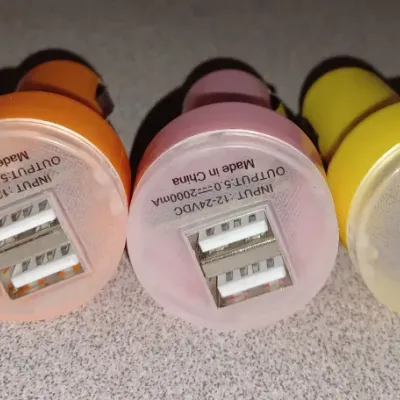 Sale Photo Thumbnail #47: Five dual-port USB car charger adapters in blue, orange, pink, yellow, and white plastic casings.