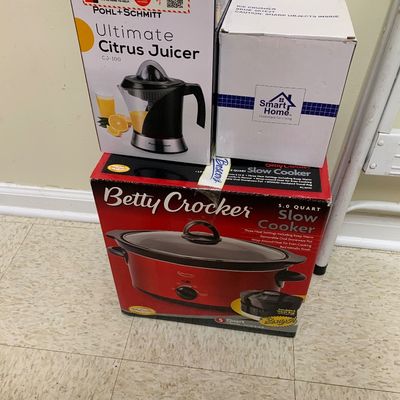 Sale Photo Thumbnail #11: Three boxed small kitchen appliances, including a Pohl + Schmitt Ultimate Citrus Juicer, a Smart Home Ice Crusher, and a Betty Crocker 5.0-quart slow cooker.