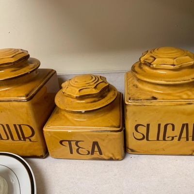 Sale Photo Thumbnail #6: Vintage mid-century ceramic kitchen canister set in a mustard yellow glaze, featuring stylized black lettering for flour, tea, and sugar.
