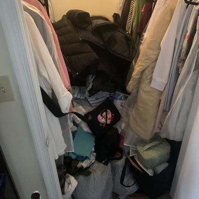 Sale Photo Thumbnail #24: Assorted women's clothing, coats, and bags hanging and piled inside a closet.