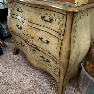 Sale Photo Thumbnail #12: French Provincial style bombee chest of drawers featuring a hand-painted floral motif, antiqued cream finish, and ornate metal pulls.