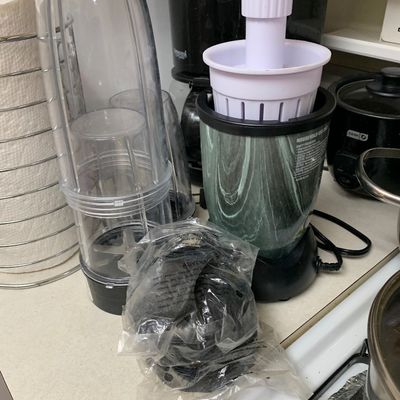 Sale Photo Thumbnail #5: Magic Bullet style personal blender with a green marbled base, multiple clear blending cups, and accessories.