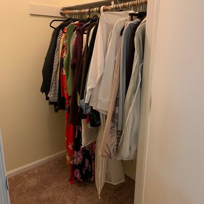 Sale Photo Thumbnail #7: Assorted women's clothing, including sweaters, dresses, and tops, hanging on a closet rod.