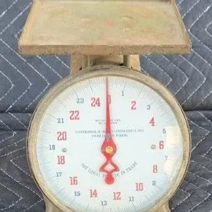 Vintage Hanson 24-pound kitchen scale with a distressed metal finish and a white dial face featuring red and black numbering.