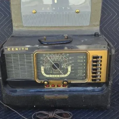 Vintage Zenith Trans-Oceanic portable shortwave radio, model H500, featuring a black textured case, gold-tone dial face, and flip-up...
