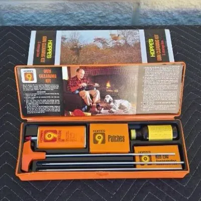 Vintage Hoppe's No. 9 gun cleaning kit in its original orange plastic storage box, complete with cleaning rods, patches, and...