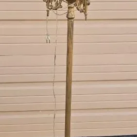 Vintage brass-finished torchiere floor lamp featuring a three-light candelabra cluster and a frosted glass shade.