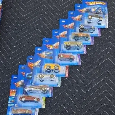 Collection of ten carded Hot Wheels die-cast toy cars from the early 2000s, arranged in a diagonal row.