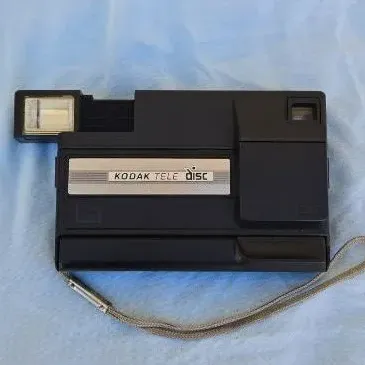 Vintage Kodak Tele Disc camera in black plastic casing with attached wrist strap, circa 1980s.