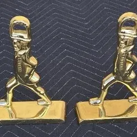 Pair of vintage brass bookends depicting marching colonial soldiers, featuring a polished finish and sturdy rectangular bases.