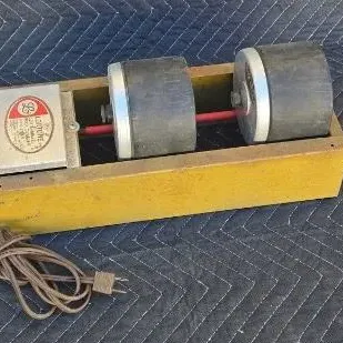 Vintage Lortone rock tumbler with a double-barrel design mounted on a yellow wooden base.