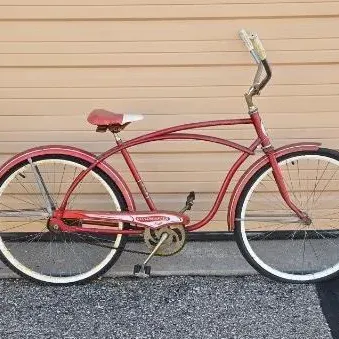 Vintage red Roadmaster cruiser bicycle featuring a classic cantilever frame, white-walled tires, and matching red fenders.