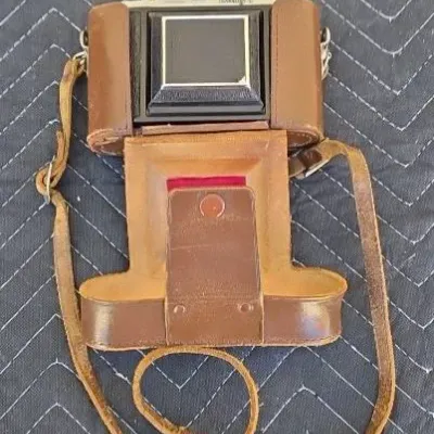Vintage Bilora Bella 44 camera housed in its original brown leather ever-ready carrying case with shoulder strap.